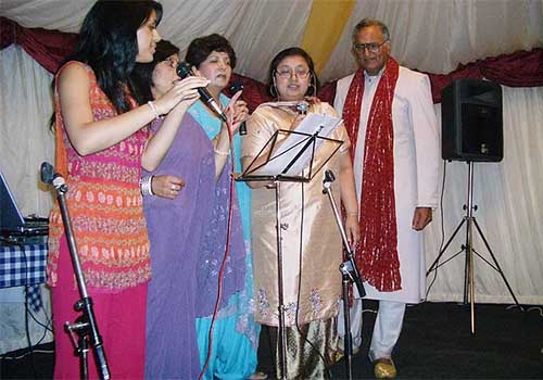 A group of ladies trying their hand at karaoke singing along with Rahi Bains